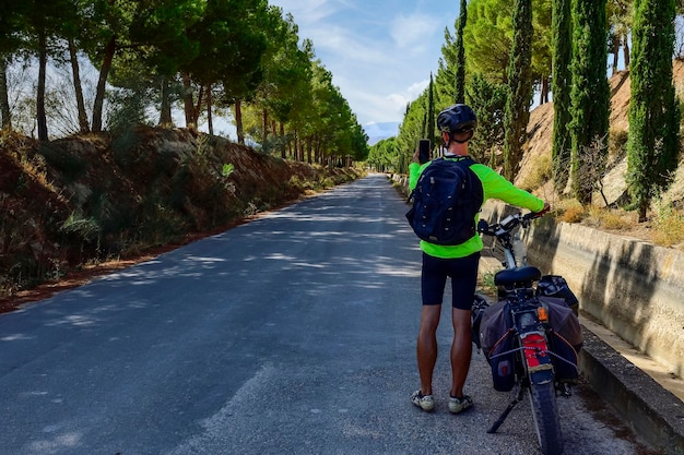 Voyageur globe-trotter à vélo contemplant la route à suivre