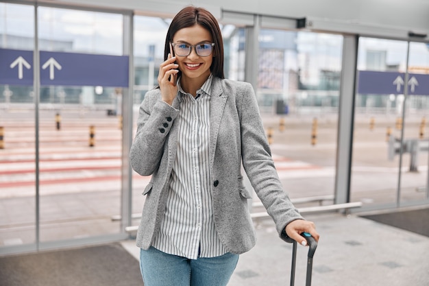 Voyageur Heureux De Femme Caucasienne Dans Le Terminal D'aéroport Avec Le Bagage