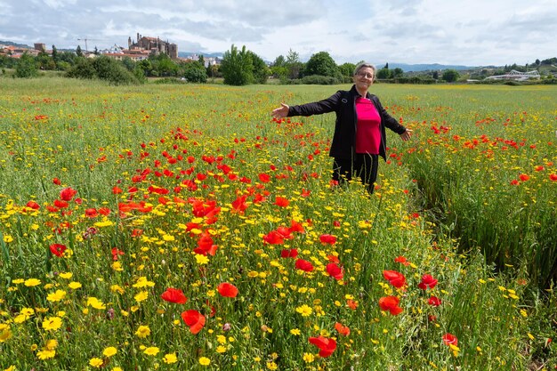 Voyageur heureux de femme mûre tenant le bouquet des fleurs rouges de pavot