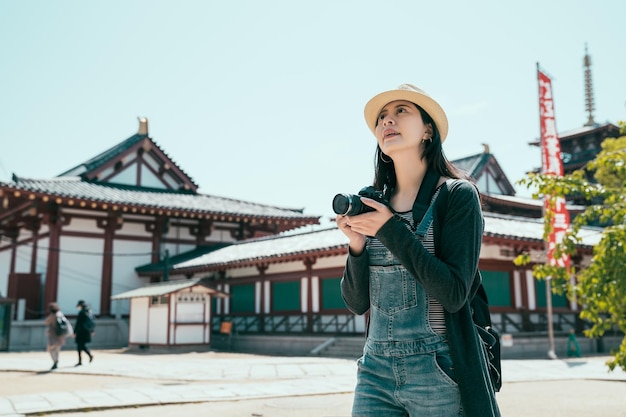 Voyageur de jeune femme prenant la photo au temple