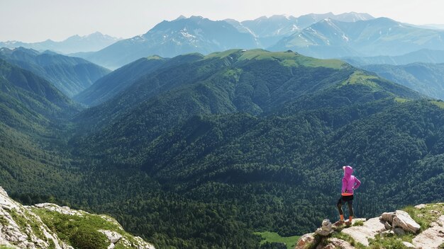 Un voyageur sur la montagne se penche sur la distance d'une réserve naturelle.