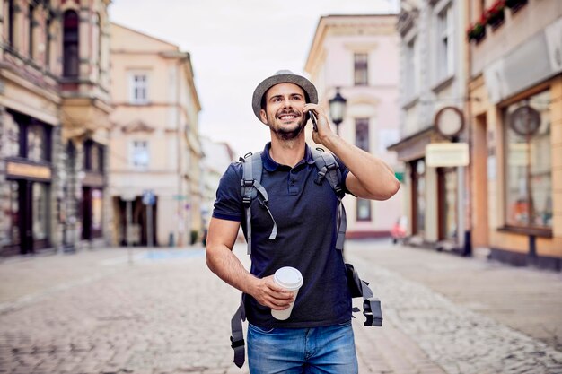 Voyageur parlant au téléphone tout en marchant dans la rue de la ville