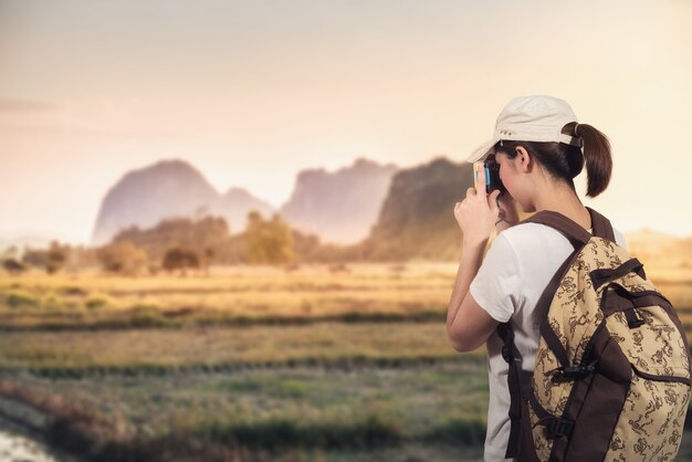 Voyageur photographiant au coucher du soleil en montagne