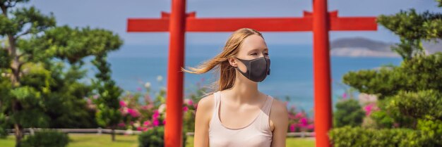 Un voyageur portant un masque médical s'est arrêté dans la rue et a regardé le bâtiment traditionnel japonais. Les touristes voyagent au Japon après l'épidémie de coronavirus.