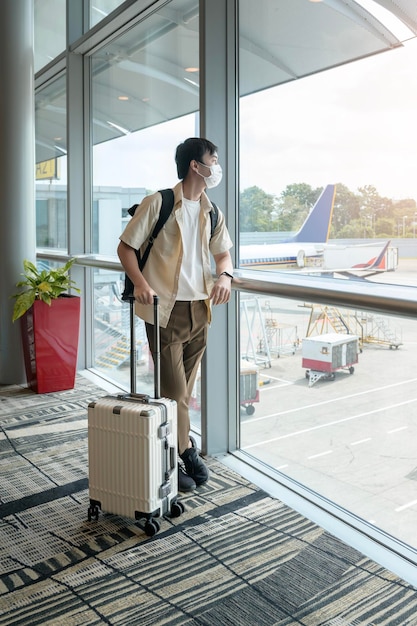 Un voyageur porte un masque de protection à l'aéroport international