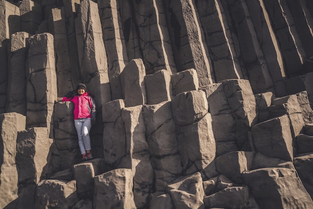 Voyageur sur des rochers hexagonaux à Vik, en Islande.