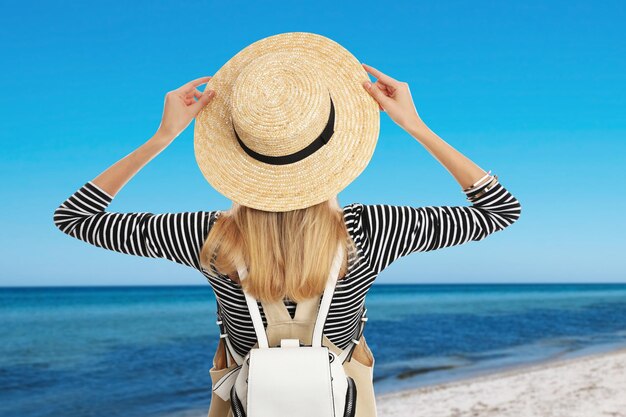 Voyageur avec sac à dos au bord de la mer pendant les vacances d'été vue arrière