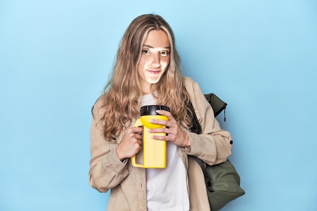 Voyageur avec sac à dos et lampe de poche dans un studio bleu