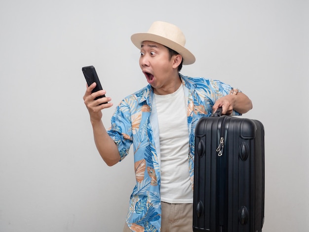 Un voyageur se sent choqué en regardant son téléphone portable