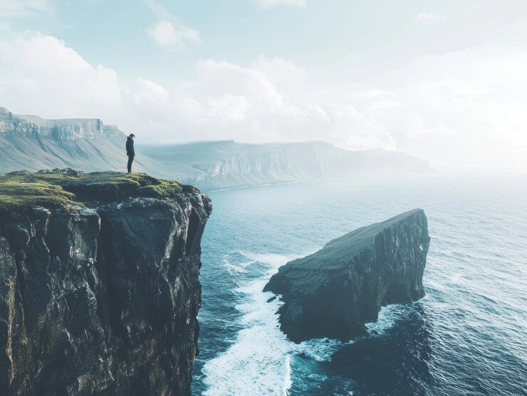 Photo un voyageur solitaire se tient sur une falaise escarpée surplombant un vaste paysage marin