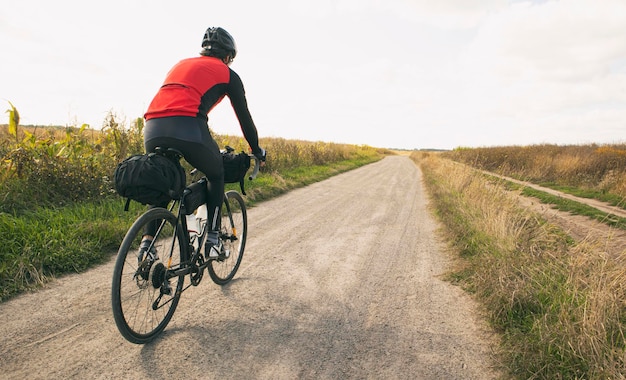 Photo voyageur à vélo à travers le champ à vélo avec des sacs