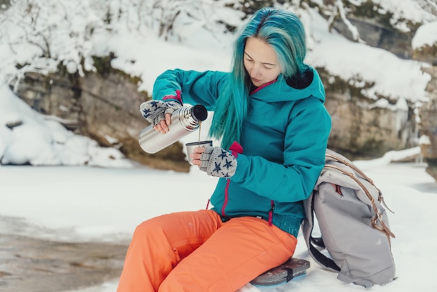 Voyageur, verser le thé dans la tasse en hiver