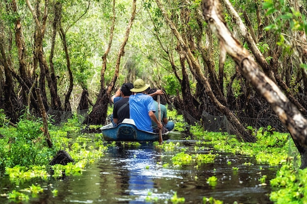 Voyageur visitant le bateau traditionnel dans la forêt de tra su, voyage dans le delta du Mékong, vietnam