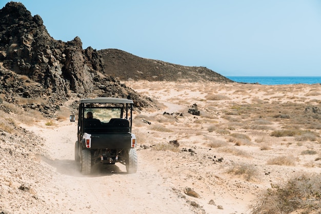 Voyageur en voiture buggy sur la plage