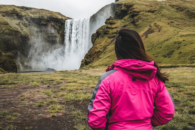 Voyageur voyage à Skogafoss Waterfall en Islande.