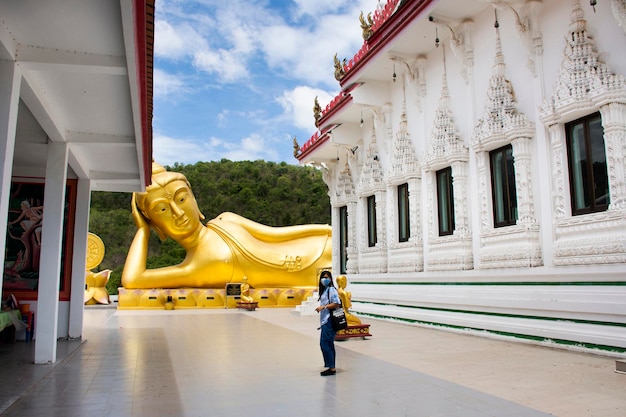 Les voyageurs asiatiques les femmes thaïlandaises voyagent visitent et respectent la statue d'attitude couchée de Bouddha du temple Wat Khao Sung Chaem Fa sur Khao Sam Sip Hap à Tha Maka le 23 mai 2021 Kanchanaburi Thaïlande