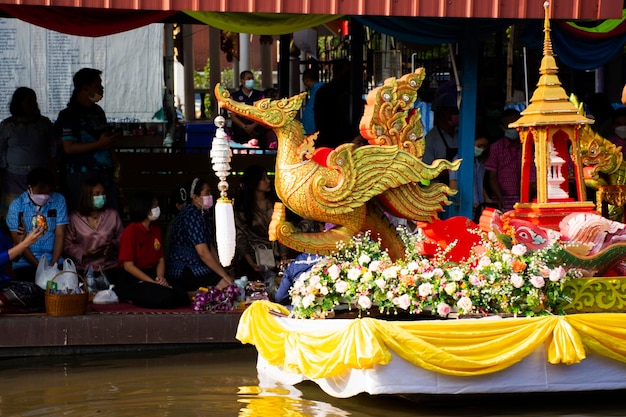 Les voyageurs étrangers thaïlandais visitent et rejoignent le rituel du mérite traditionnel et la prière offrant l'aumône à la procession des moines sur le bateau dans le canal de Wat Sai Yai le 8 novembre 2022 à Nonthaburi en Thaïlande