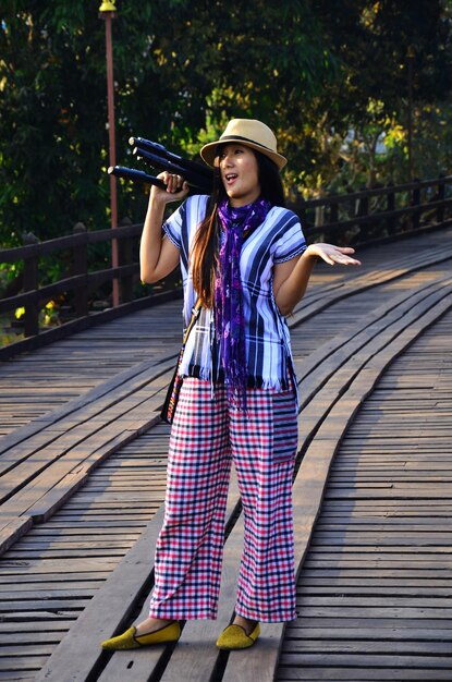 Voyageurs femmes thaïlandaises voyagent visite et portrait posant pour prendre une photo sur Saphan Mon ou Uttamanusorn le plus long pont en bois traversant la rivière Mae Klong à la ville de Sangkhla Buri à Kanchanaburi en Thaïlande