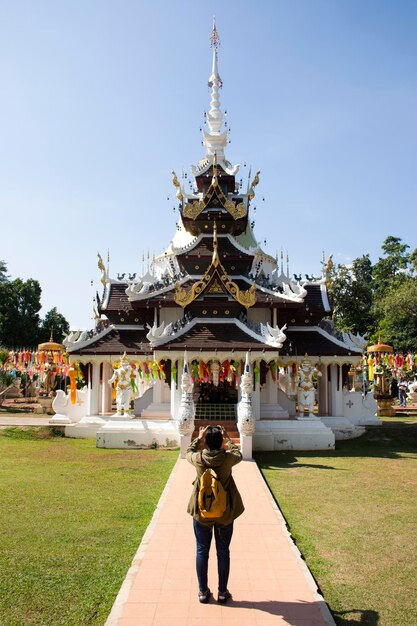 Les voyageurs femmes thaïlandaises voyagent visiter le respect prier et utiliser un téléphone mobile intelligent prendre des photos ruines antiques bâtiment sanctuaire du temple Wat Pa Dara Phirom à la ville de Mae Rim à Chiang Mai Thaïlande