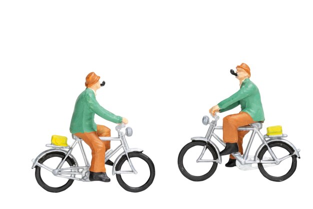 Des voyageurs en miniature avec des vélos isolés sur fond blanc avec un sentier coupé