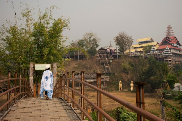 Les voyageurs thaïlandais voyagent à pied sur le pont en bois de bambou Su Tong Pae du temple Phu Sa Ma tandis que PM 25 Situation de poussière dans le village de Ban Kung Mai Sak à Pai ville de Mae Hong Son Thaïlande