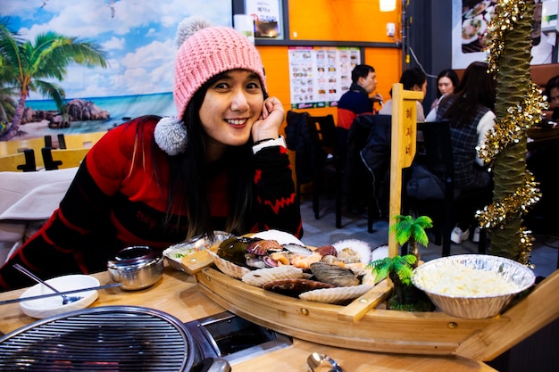 Les voyageurs thaïlandais voyagent visiter manger boire et prendre des photos avec des fruits de mer rôtis grillés et des coquillages dans un restaurant local au Haeundae Street Food Market le 18 février 2023 à Busan en Corée du Sud