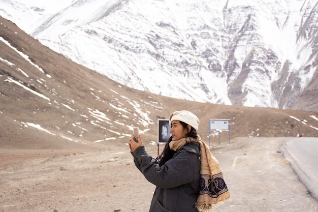 Les voyageurs visitent une femme thaïlandaise et posent pour prendre une photo avec un paysage de montagne haut de gamme sur l'autoroute Srinagar Leh Ladakh au village de Leh Ladakh au Jammu-et-Cachemire en Inde pendant la saison d'hiver