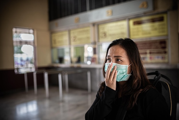 Une voyageuse asiatique porte un masque pour protéger le coronavirusUne femme thaïlandaise portant un masque respiratoire protège et filtre les particules pm25