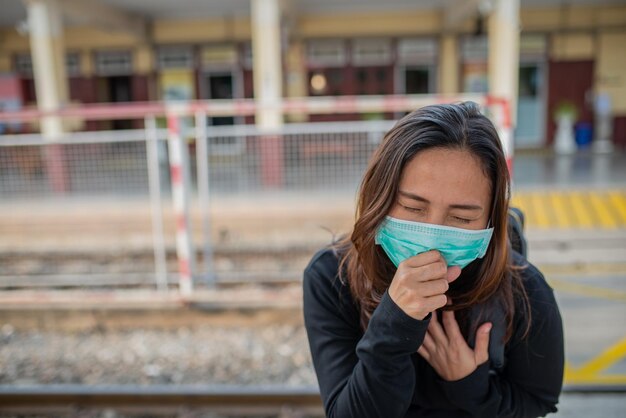 Une voyageuse asiatique porte un masque pour protéger le coronavirusUne femme thaïlandaise portant un masque respiratoire protège et filtre les particules pm25