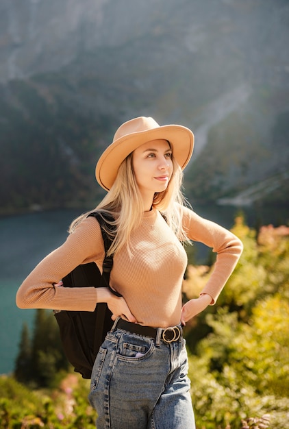 Voyageuse femme portant un chapeau et regardant des montagnes et un lac incroyables, concept de voyage à l'aventure. Lake Morskoy Eye dans les Tatras polonaises.