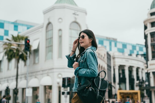 voyageuse marchant dans la rue de Beverly Hills, elle porte des lunettes de soleil à la mode