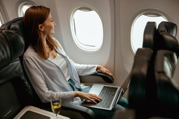 Voyageuse utilisant un ordinateur portable dans un avion de passagers