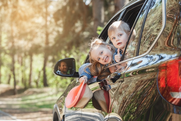 Voyagez en voiture, balade en famille, frère et sœur se penchent par la fenêtre