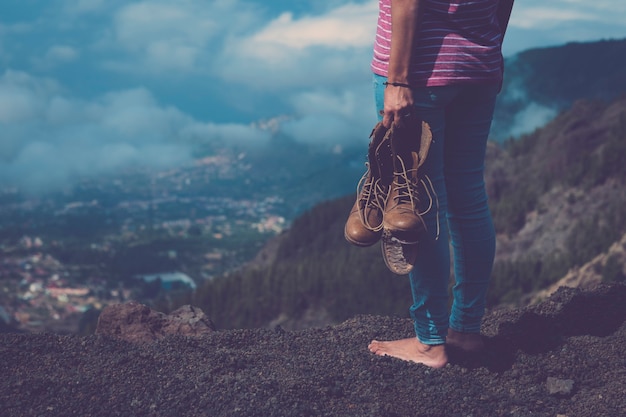 Voyagez et voyagez, explorez et profitez du monde en découvrant un lieu pittoresque pour des vacances alternatives ou une image de concept de style de vie de voyageur millénaire avec une fille debout avec une chaussure de trekking cassée