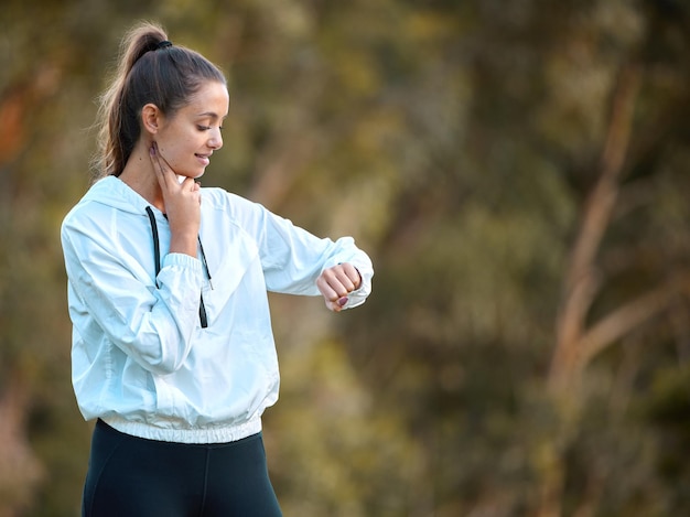 Voyons à quel point je suis vraiment en forme Photo d'une jeune femme sportive vérifiant son pouls pendant l'exercice à l'extérieur