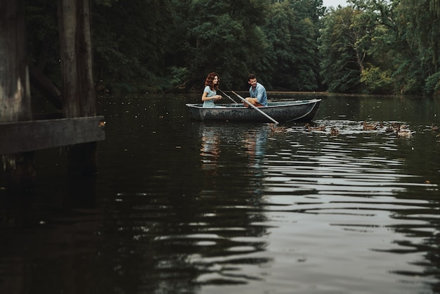 Vrai amour. Beau jeune couple souriant et nourrissant des canards tout en profitant d'un rendez-vous romantique sur le lac