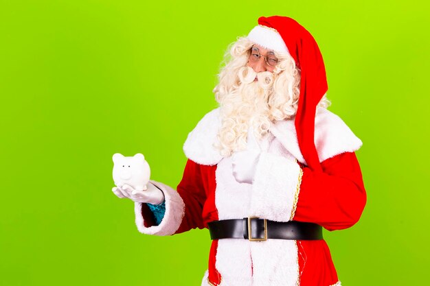 Vrai Père Noël tenant une tirelire dans ses mains avec un espace libre pour le texte sur un fond vert concept de finance de Noël