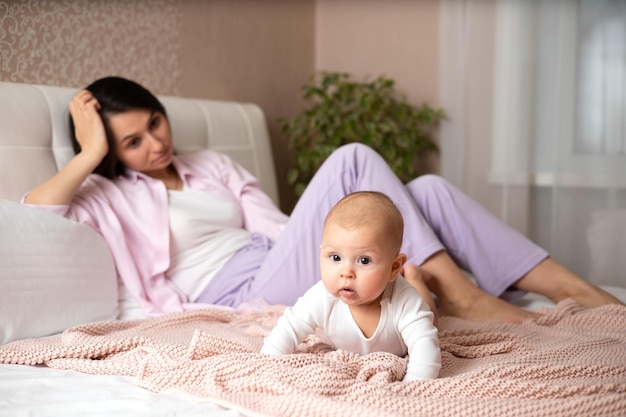 Vraie maternité Une maman fatiguée dans la chambre avec son bébé Maux de tête Mode de vie Parent