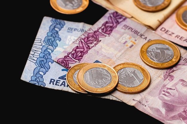 vrais billets et pièces de monnaie brésiliens brl sur un bureau sombre