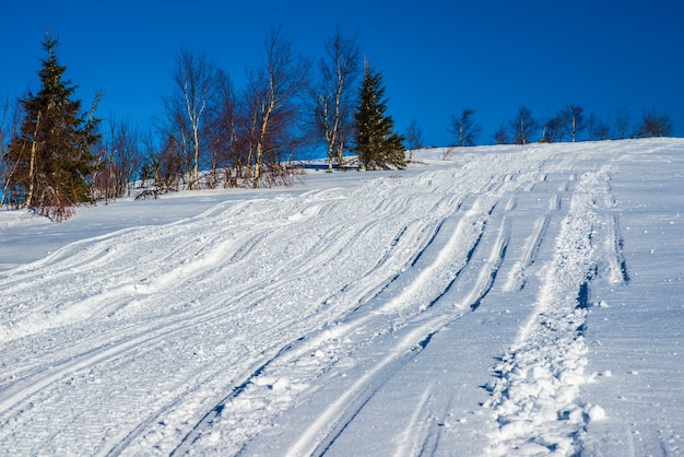 VTT et pistes de ski dans la neige par une journée d'hiver glaciale et ensoleillée. Concept de détente dans les montagnes d'hiver en Europe.