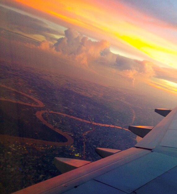 Photo vue aérienne d'une aile d'avion au-dessus de la mer au coucher du soleil