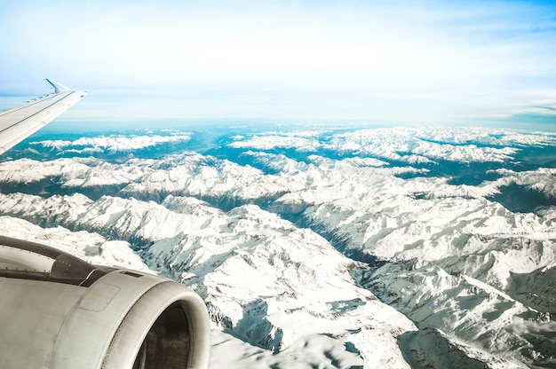 Vue aérienne des Alpes européennes avec horizon brumeux et partie du moteur d'aile d'avion