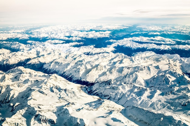 Photo vue aérienne des alpes italiennes avec neige et horizon brumeux concept de voyage et vacances d'hiver sur les montagnes enneigées blanches voyage errer vers des destinations de luxe exclusives