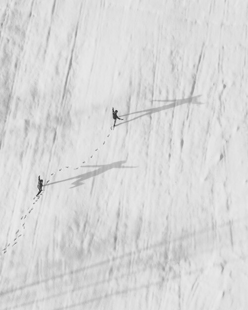 Photo vue aérienne d'amis marchant sur un champ couvert de neige