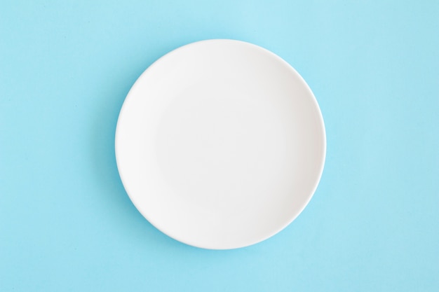 Vue aérienne d&#39;une assiette vide blanche sur fond bleu