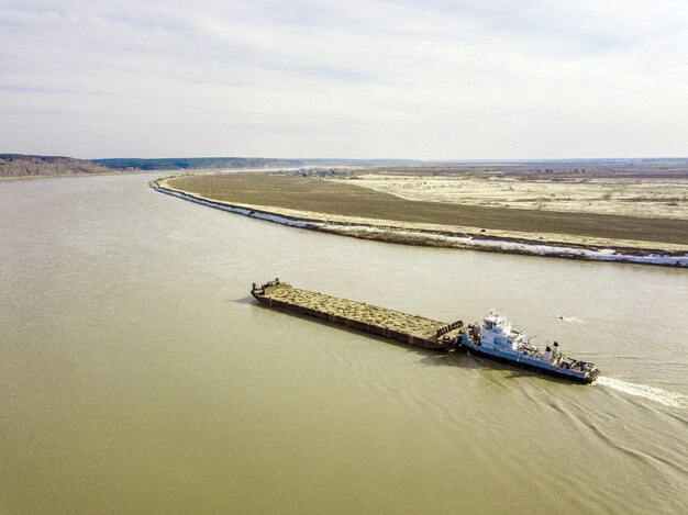 Photo vue aérienne de barge sur la rivière tom, au début du printemps en sibérie, tomsk, russie.