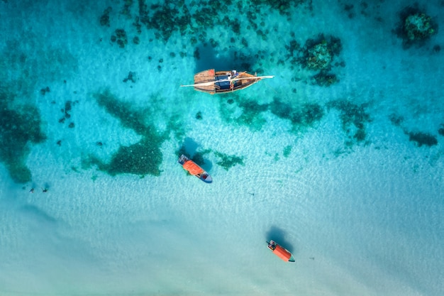 Vue aérienne des bateaux de pêche dans une eau bleu clair à une journée ensoleillée en été