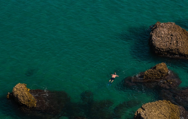 Vue aérienne de la belle plage de Nerja en Espagne avec un homme faisant de la plongée avec tuba