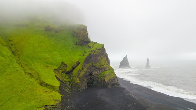 Photo vue aérienne des belles formations rocheuses célèbres reynisdrangar à la plage noire de reynisfjara,