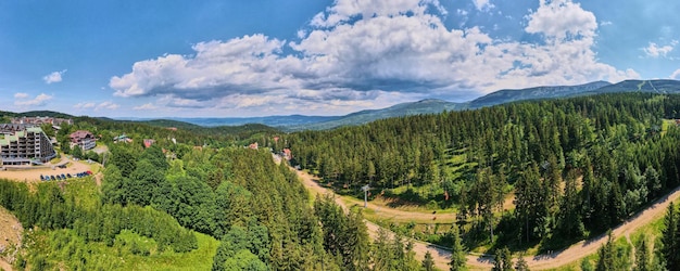 Vue aérienne de belles montagnes couvertes de forêt et de route de téléphérique ouverte long panorama karpacz